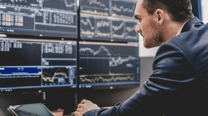 Jak využít buy the dip strategie? Člověk dívající se na monitor s grafy